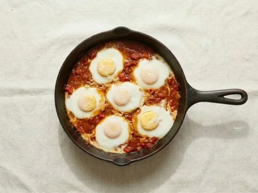 Six eggs cooking in the sauce